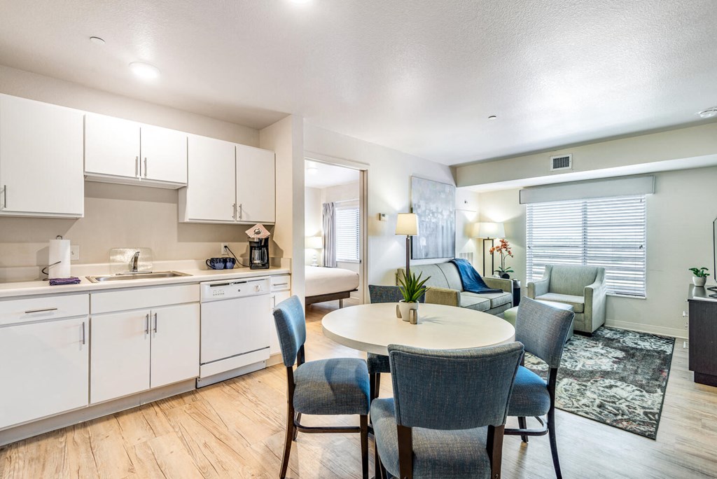 a kitchen with white cabinets and a table and chairs at Parks Residential - Denver, Centennial, CO 80111