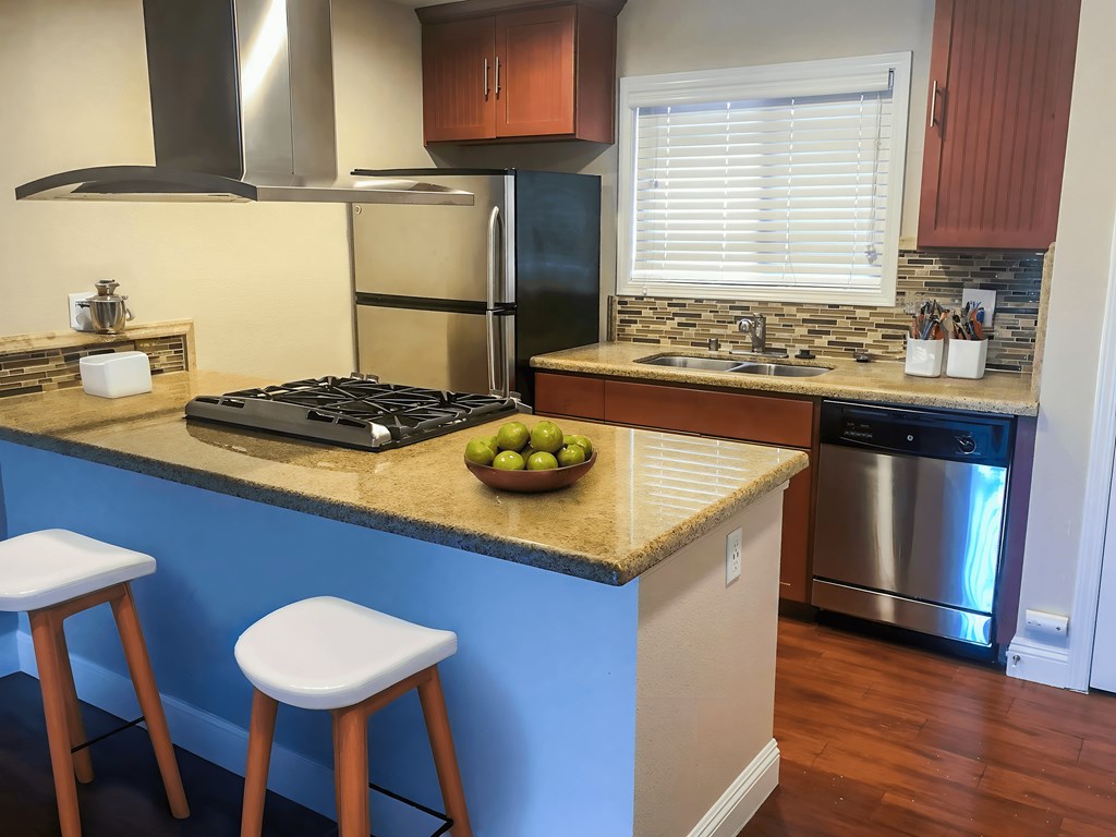 A kitchen with a blue counter and a stove.
