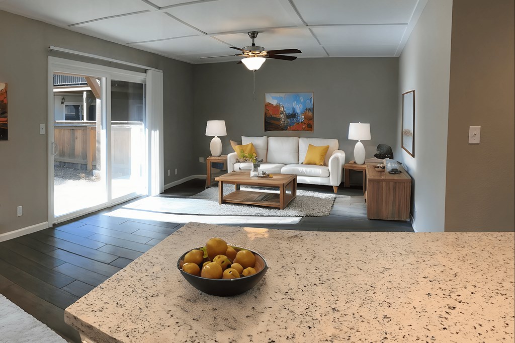 A bowl of oranges sits on a counter in a well-lit room.