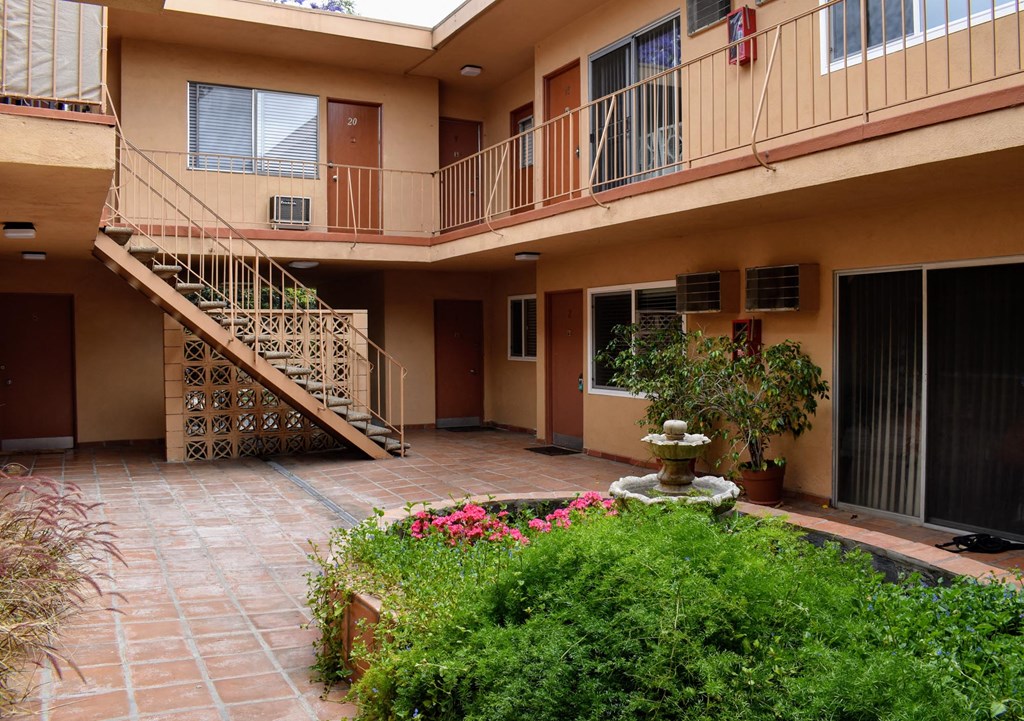 a courtyard with a fountain in front of an apartment building