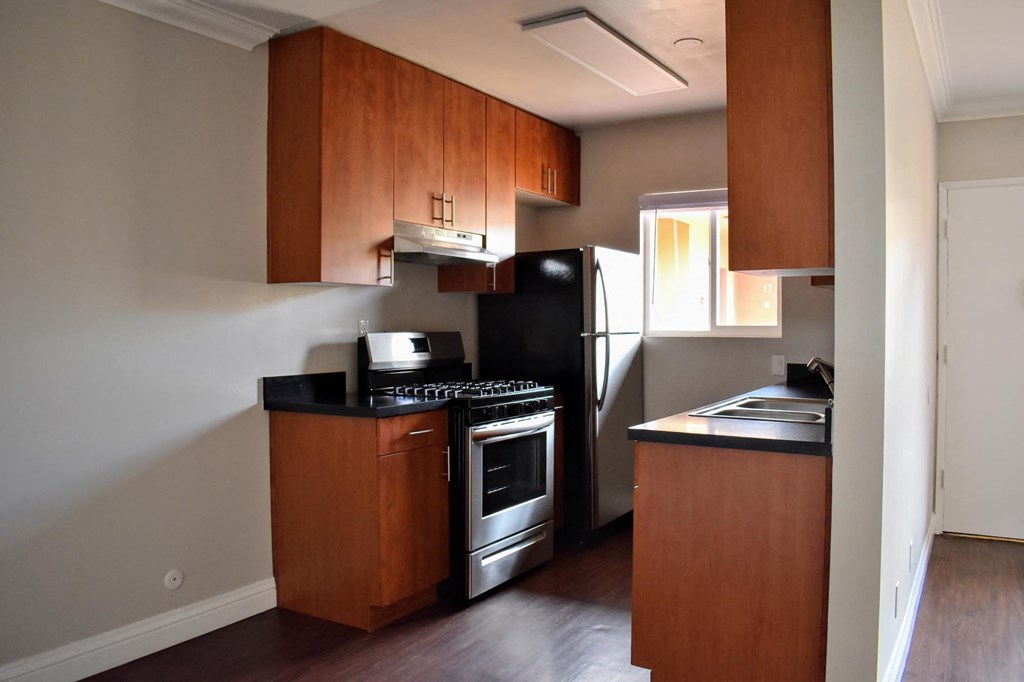 a kitchen with wooden cabinets and a stove and a refrigerator