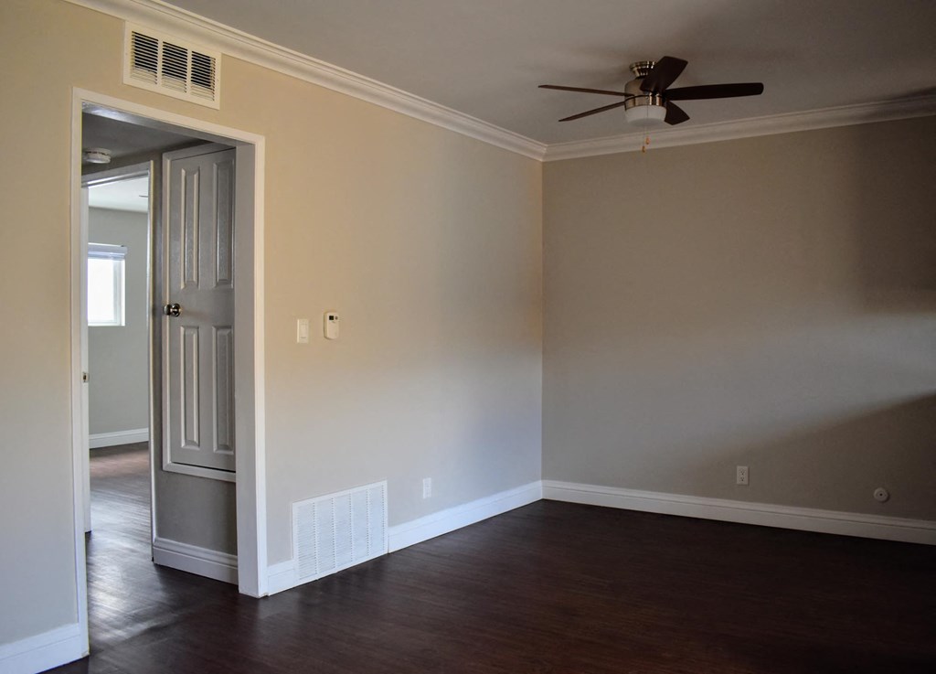 a empty room with a ceiling fan and a door
