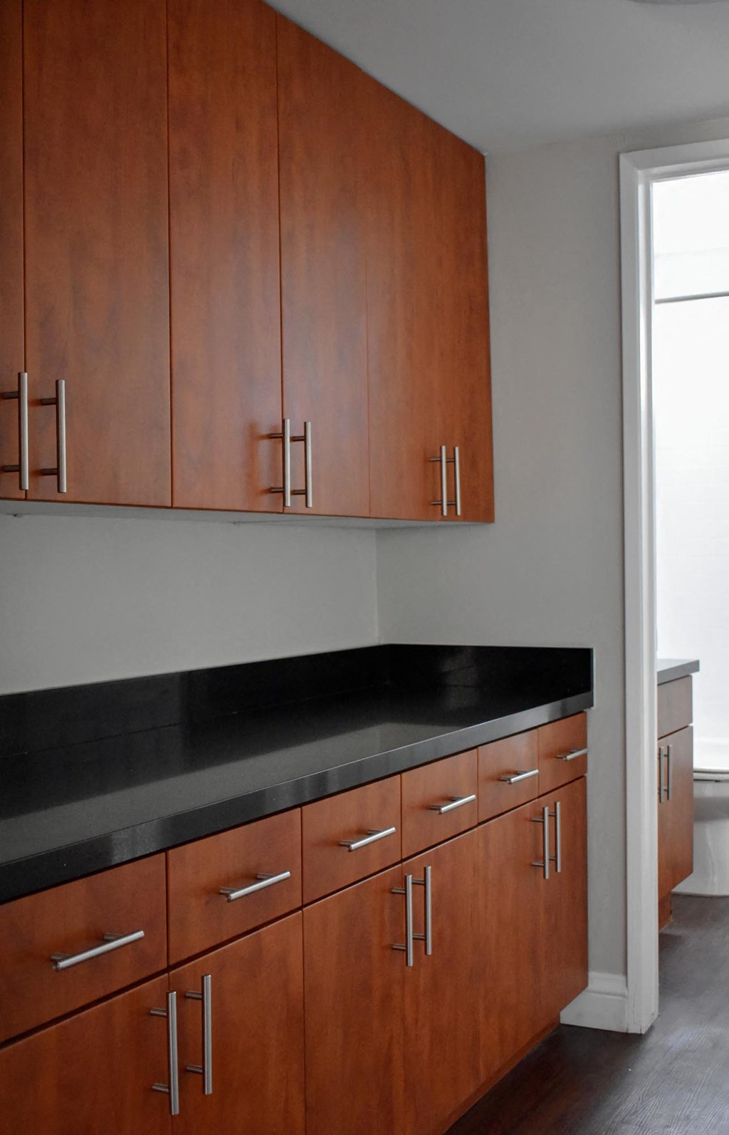 a kitchen with wooden cabinets and a black counter top