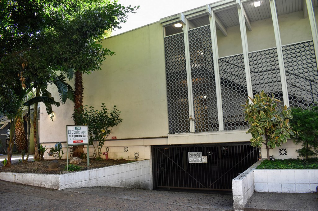 a building with a gate and a tree in front of it