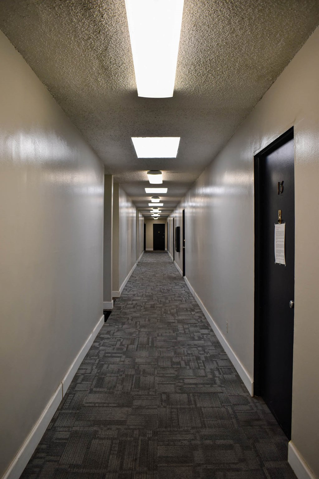 a long hallway with doors and a ceiling light