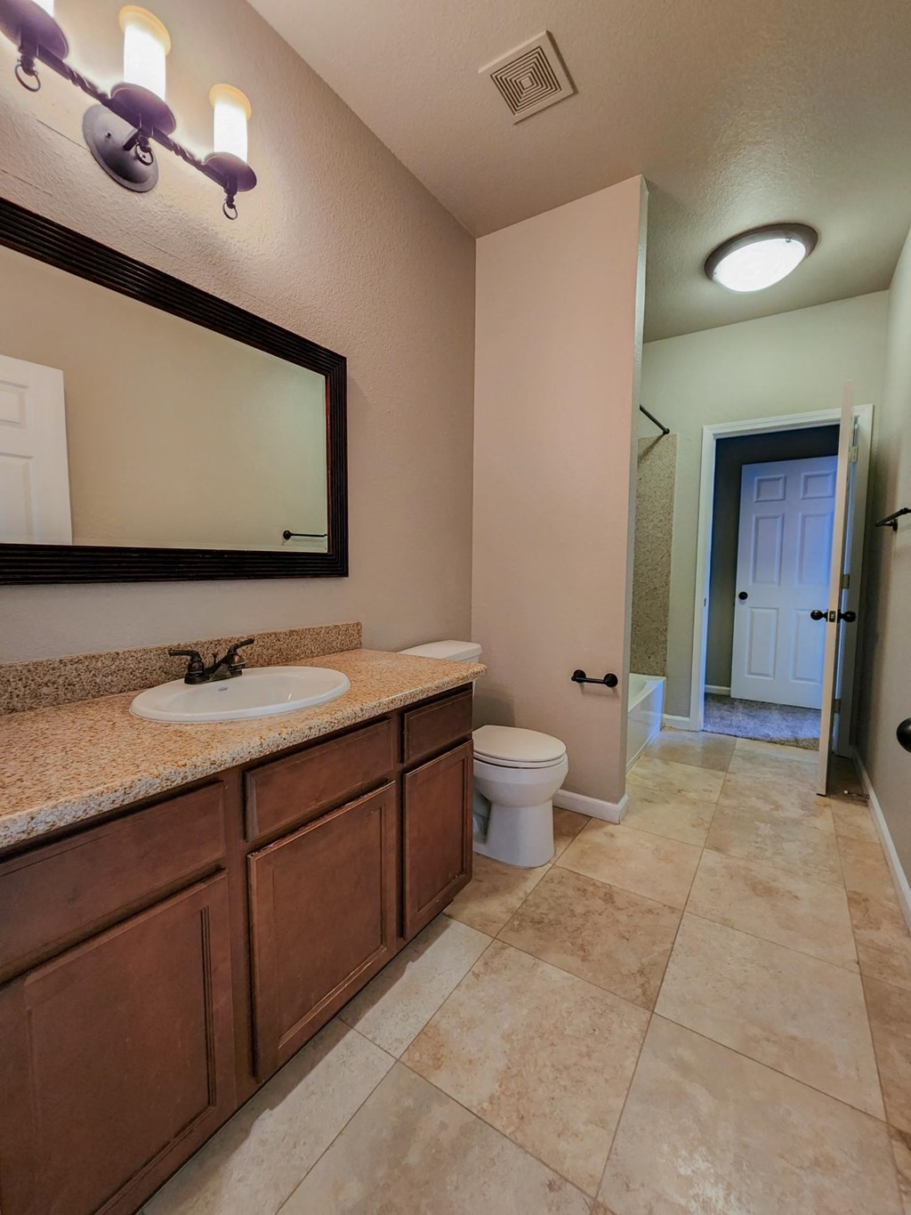 Bathroom with vanity and travertine  in Elmwood Floor plan