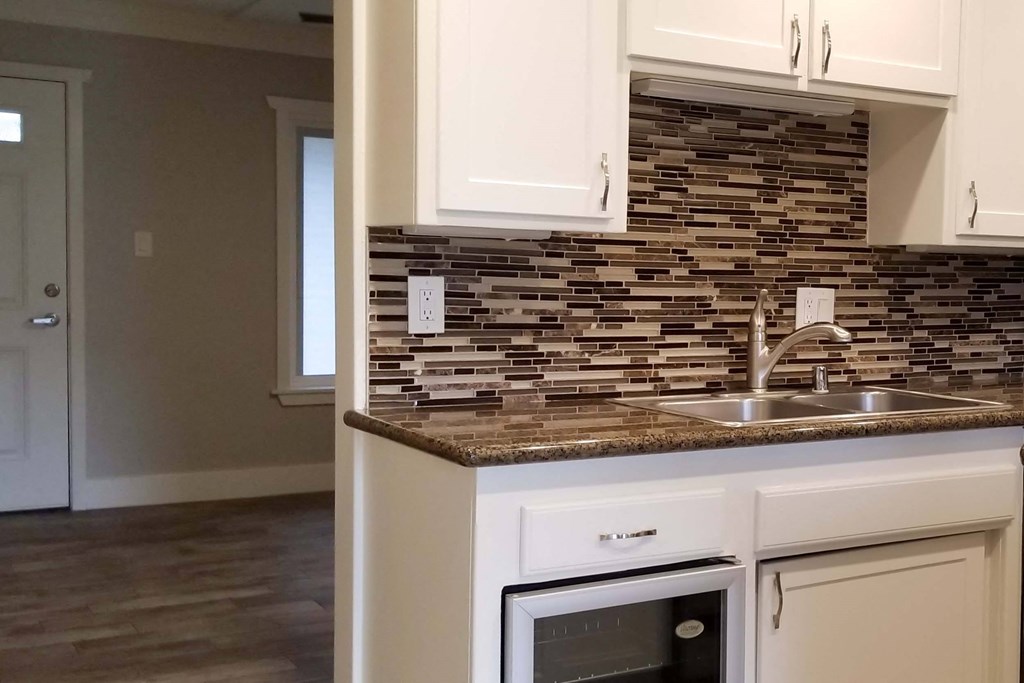a kitchen with white cabinets and a counter top and a sink