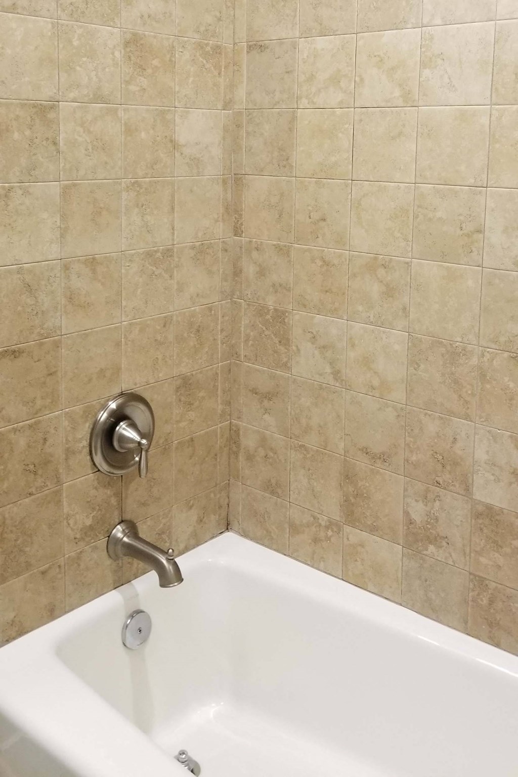 a bathroom with a bath tub and a tiled shower