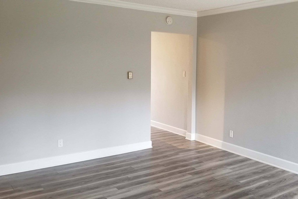 an empty living room with wood floors