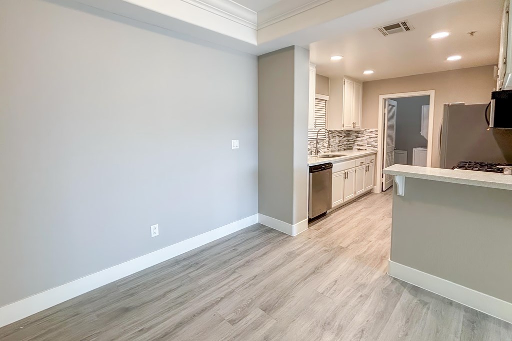 A kitchen with a white countertop and a grey floor.