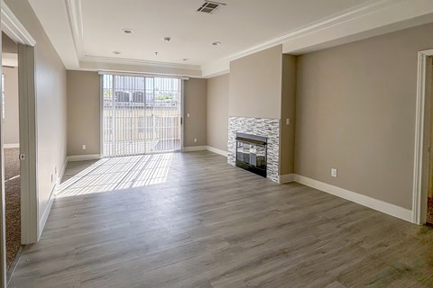 A spacious living room with a fireplace and hardwood floors.