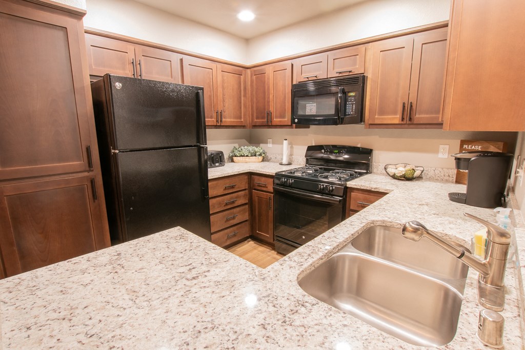 a kitchen with black appliances and granite counter tops