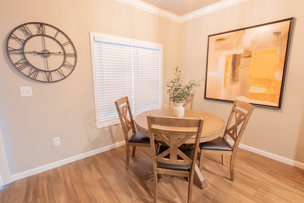 a dining room with a table and chairs and a large clock