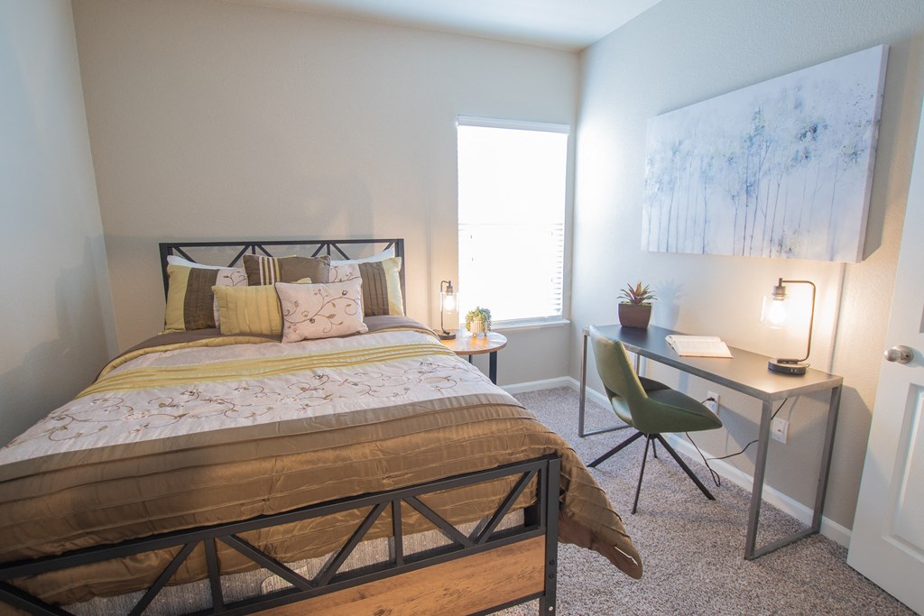 a bedroom with a bed and a desk with a chair