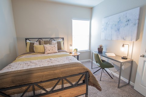 a bedroom with a bed and a desk with a chair
