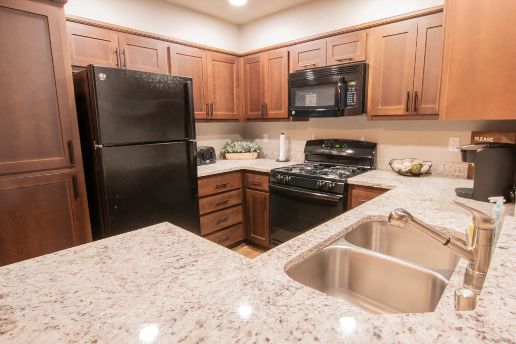 a kitchen with black appliances and granite counter tops