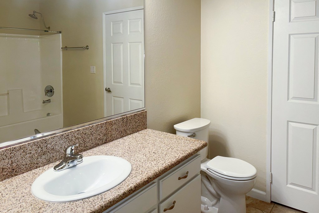 A bathroom with a sink, toilet and shower.
