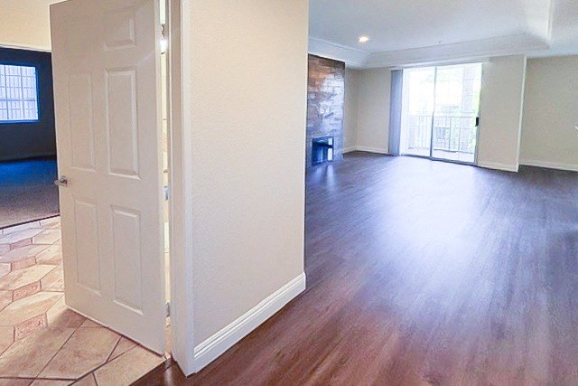 A room with a white door and a brick wall.