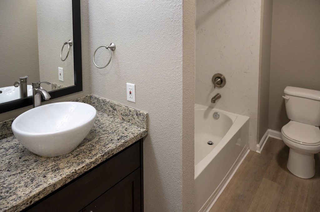 A white sink is on a granite countertop at Sierra Oaks Living Apartments, California 95682