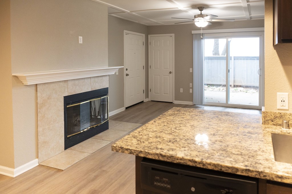 A kitchen with a granite countertop and a fireplace at Sierra Oaks Living Apartments, Cameron Park, CA