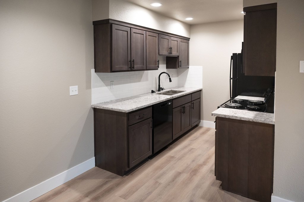 A kitchen with dark brown cabinets and a white countertop at Sierra Oaks Living Apartments, Cameron Park