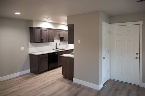 A kitchen with brown cabinets and a white door.