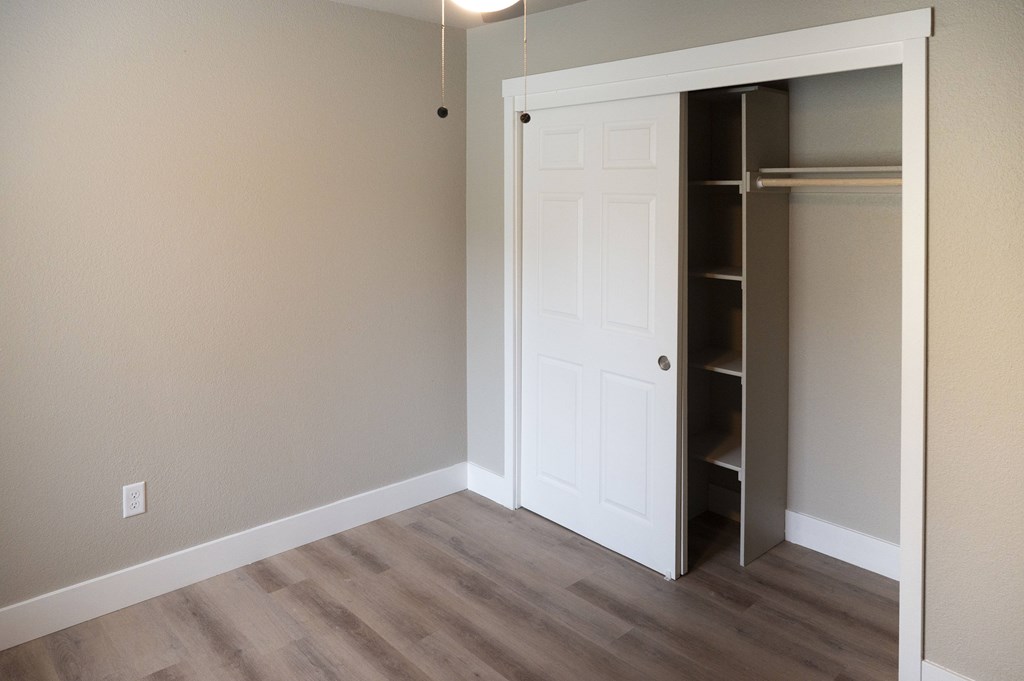 A white door is open to a pantry with shelves at Sierra Oaks Living Apartments, Cameron Park, CA