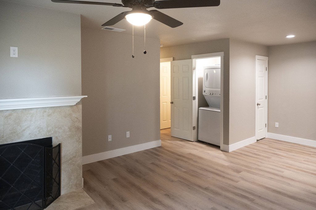 A room with a fireplace and a ceiling fan at Sierra Oaks Living Apartments, California 95682