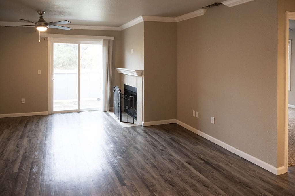 A room with a fireplace and sliding glass doors at Sierra Oaks Living Apartments, Cameron Park, California