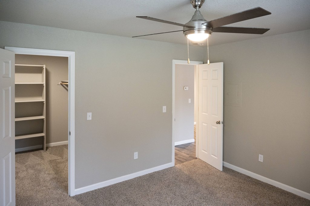 A room with a ceiling fan and two doors, one of which is open at Sierra Oaks Living Apartments, Cameron Park, CA 95682