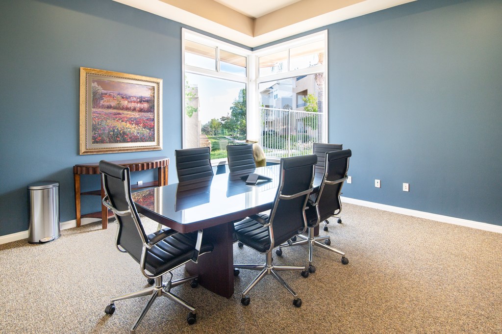 A conference room with a large table and chairs.
