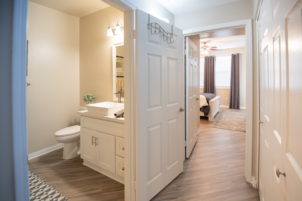 A bathroom with a toilet, sink, and mirror is shown.