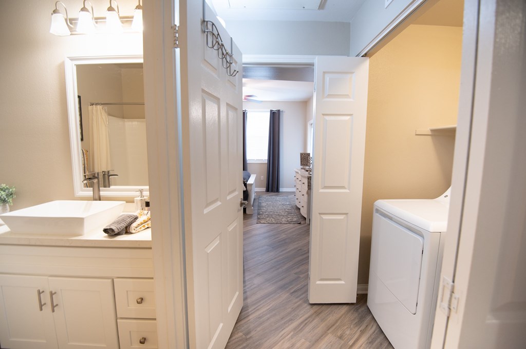 A bathroom with a white sink and a white door.
