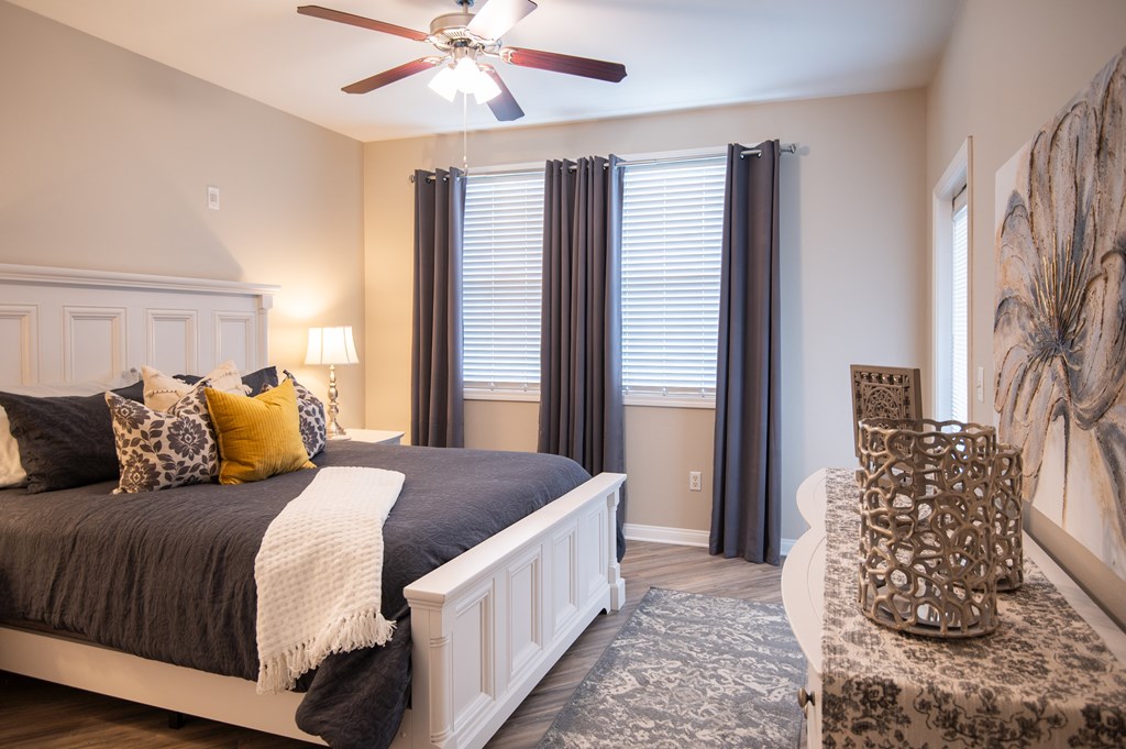 A bedroom with a large bed and a ceiling fan.