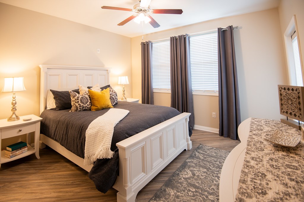 A bedroom with a large bed and a ceiling fan.