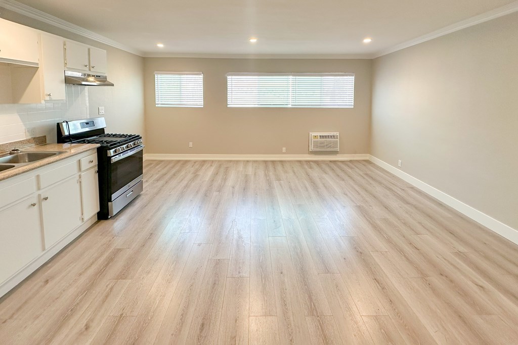 A kitchen with wooden floors and a stove top oven.