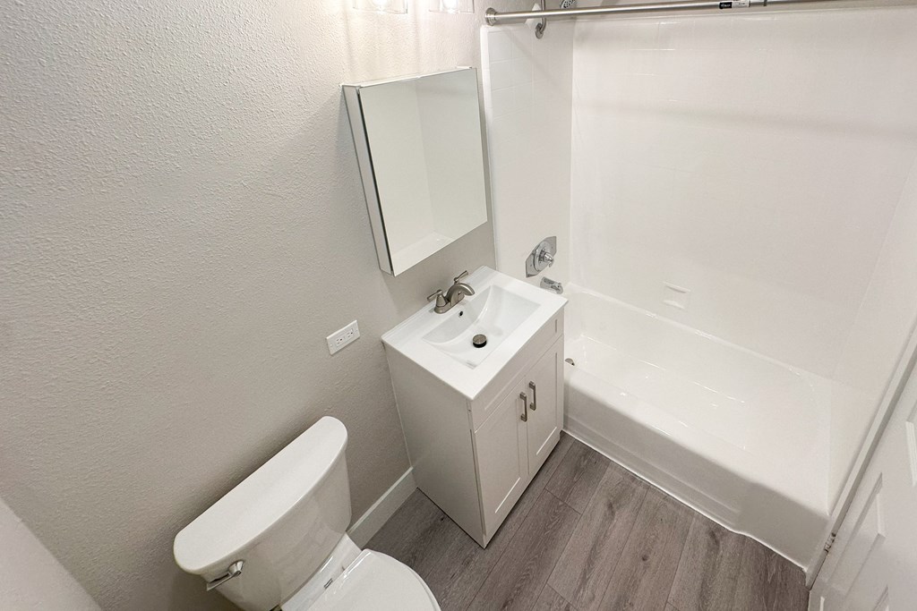 A white bathroom with a toilet, sink, and bathtub.