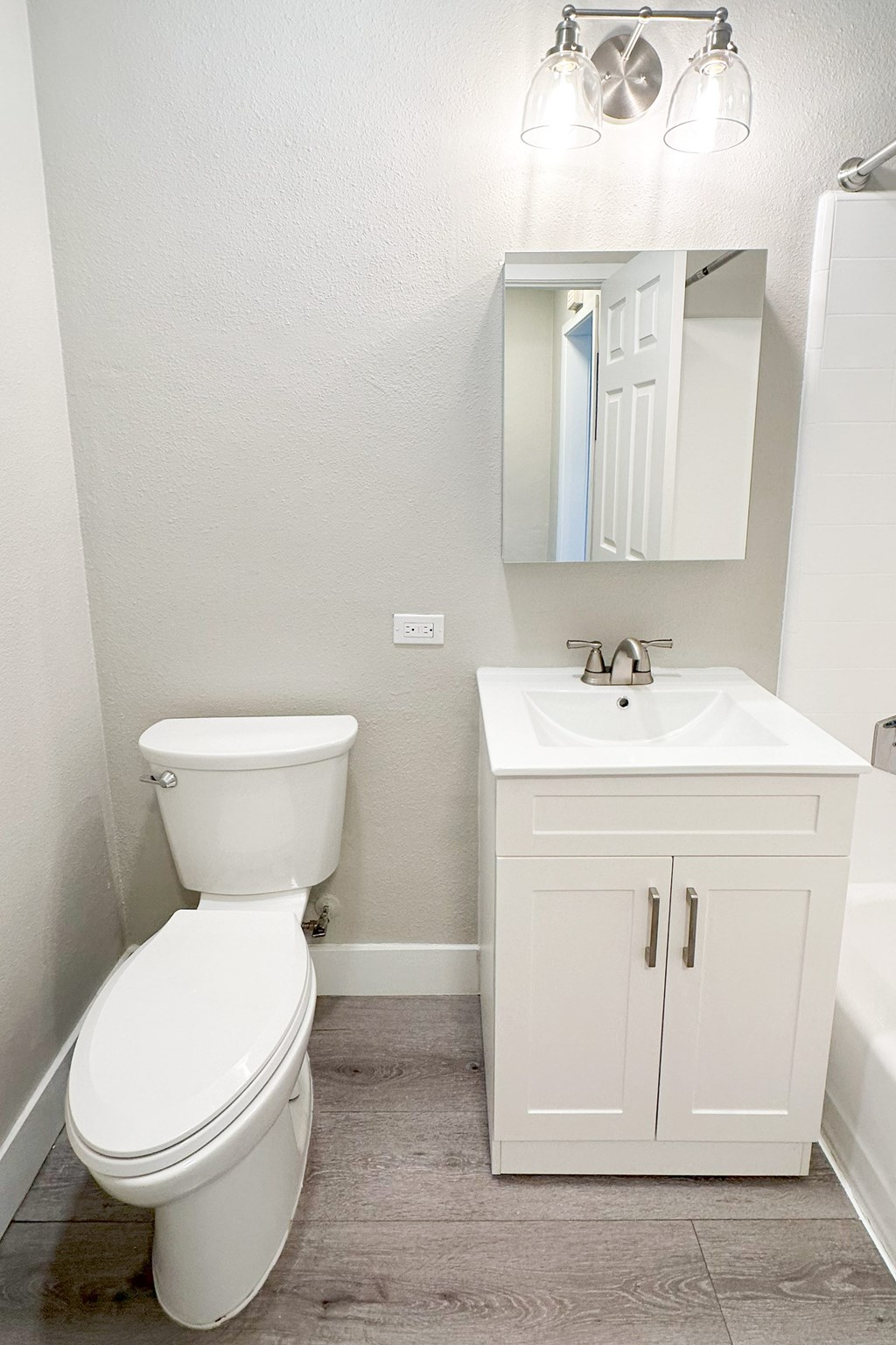 A white toilet sits next to a sink in a bathroom.