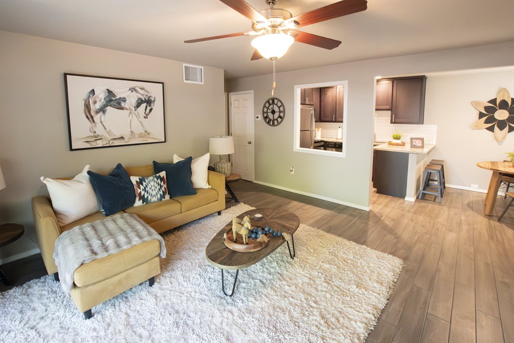 A living room with a couch, coffee table, and a ceiling fan.
