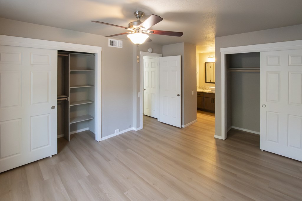 A room with a ceiling fan and open doors.