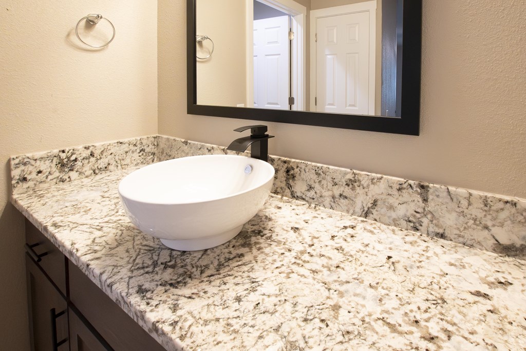 A white sink is on a marble countertop.