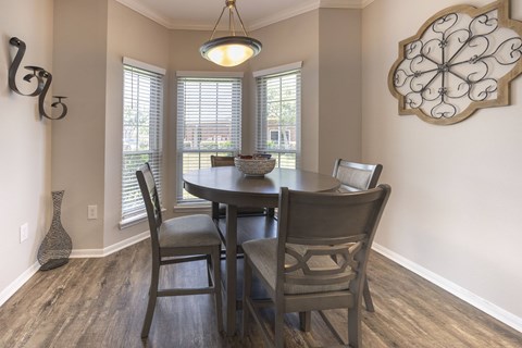 A dining room with a table and chairs.