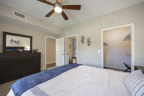 A bedroom with a large bed and a ceiling fan.