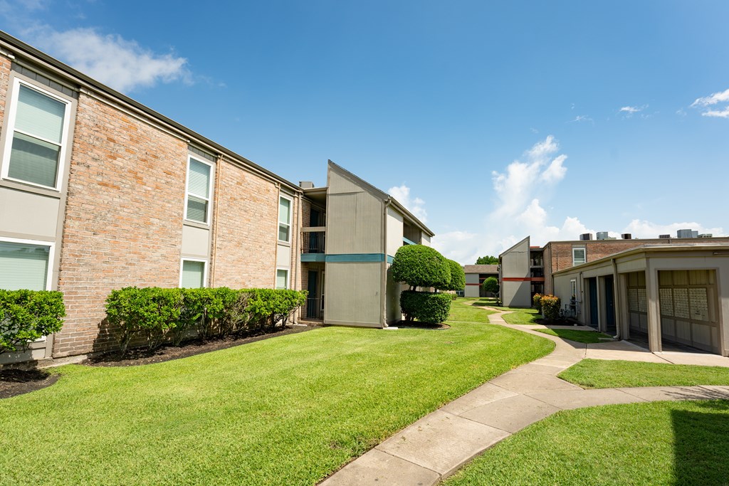 A sunny day at a residential area with apartment buildings and green lawns.