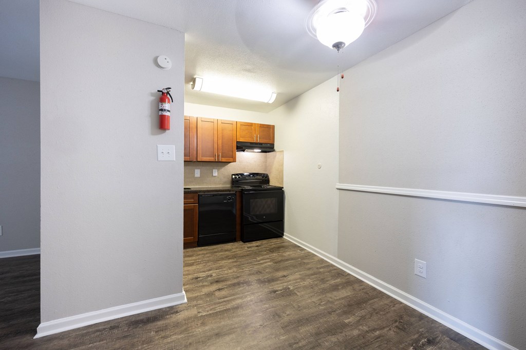 A kitchen area with a black oven and microwave.