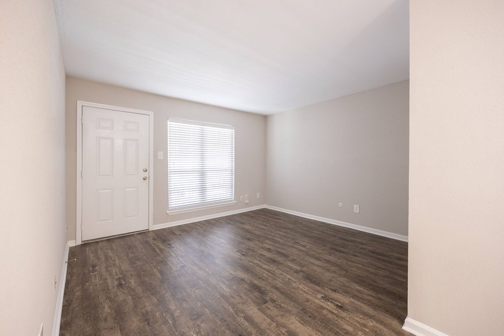 A room with a white door and a window with blinds.