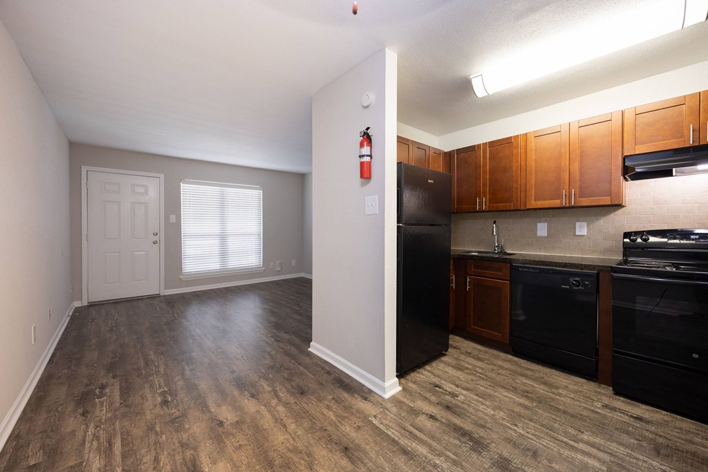 A kitchen with black appliances and wooden cabinets.
