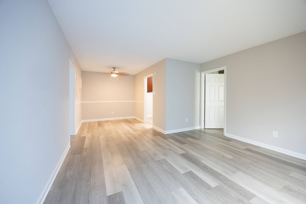 A room with light wood flooring and white walls.