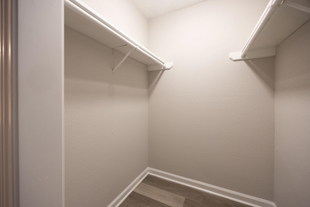 A white closet with a stairway leading to the second floor.