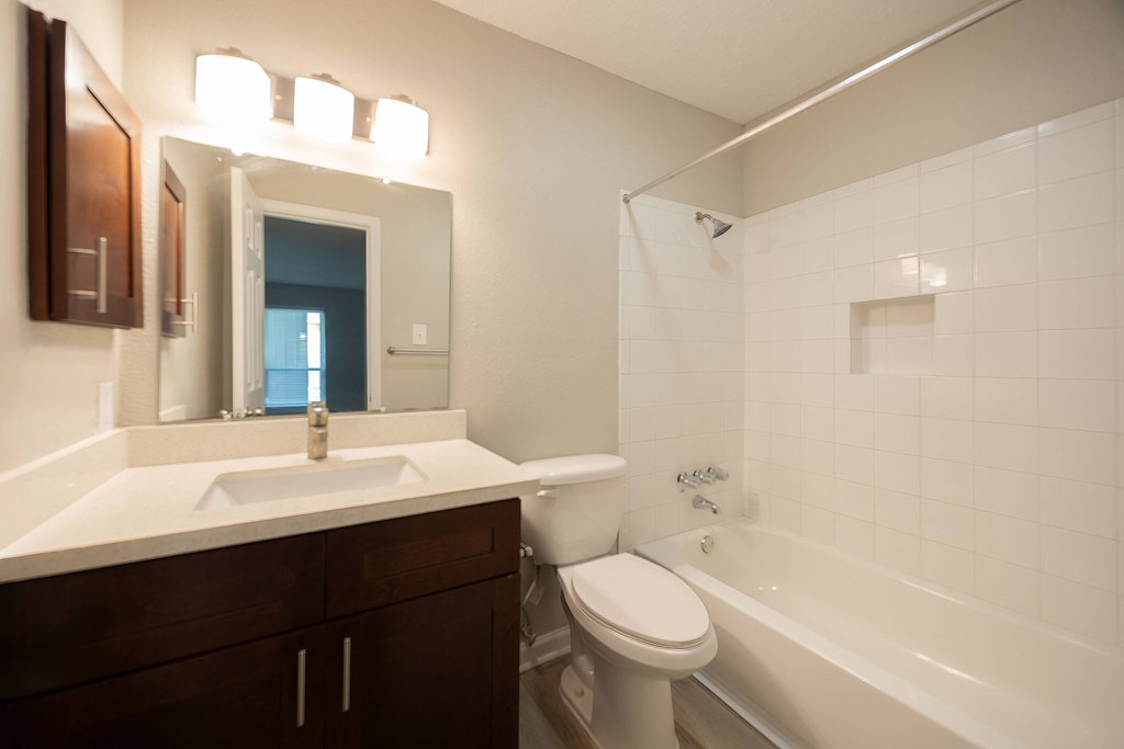 A white sink is in a bathroom with a white toilet and a white tub.